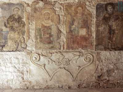 Sulla muratura in basso � poi presente un elemento a volute con decori vegetali...
